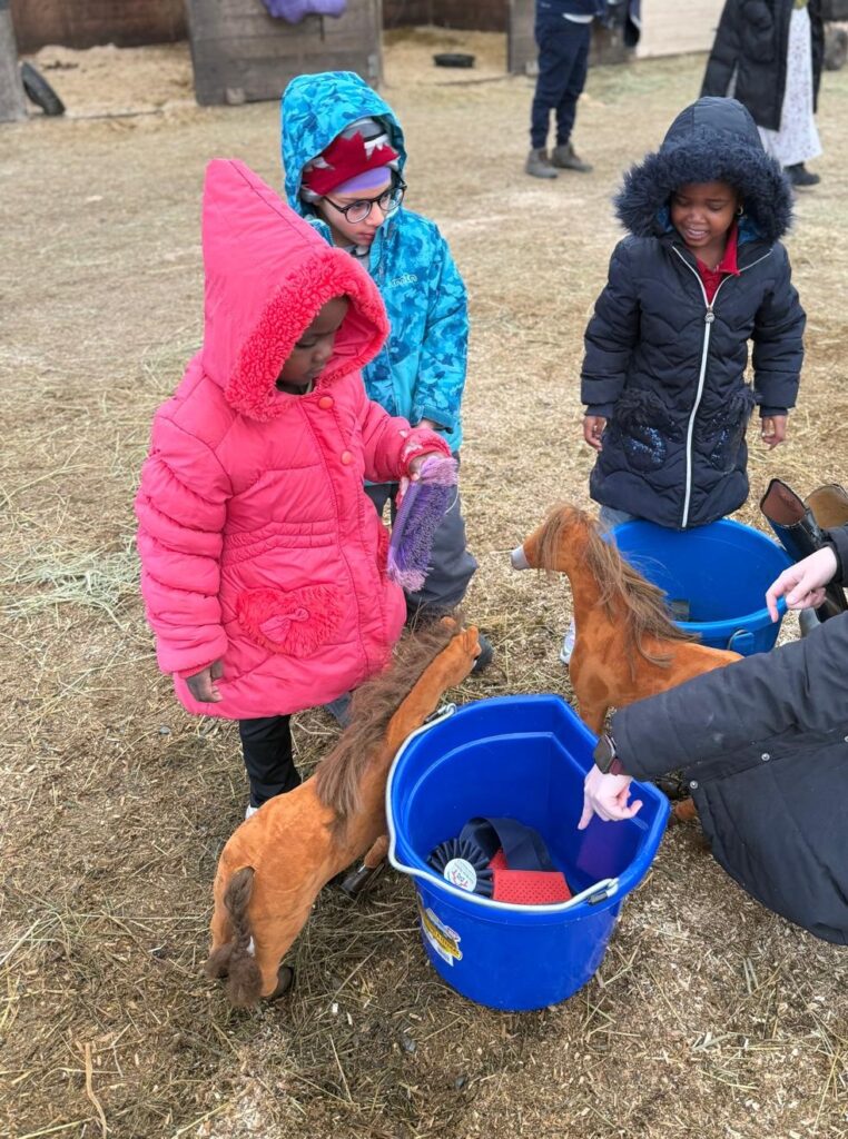 Children checking out stuffed horses on the farm. 